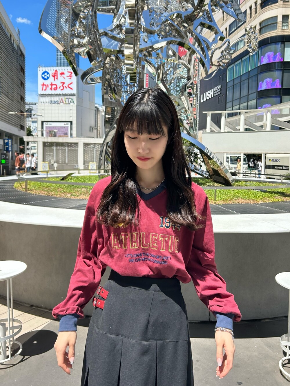 レッド系のTシャツ/カットソー、ブラック系のスカートを着用したレディースの夏コーディネートの2枚目の写真