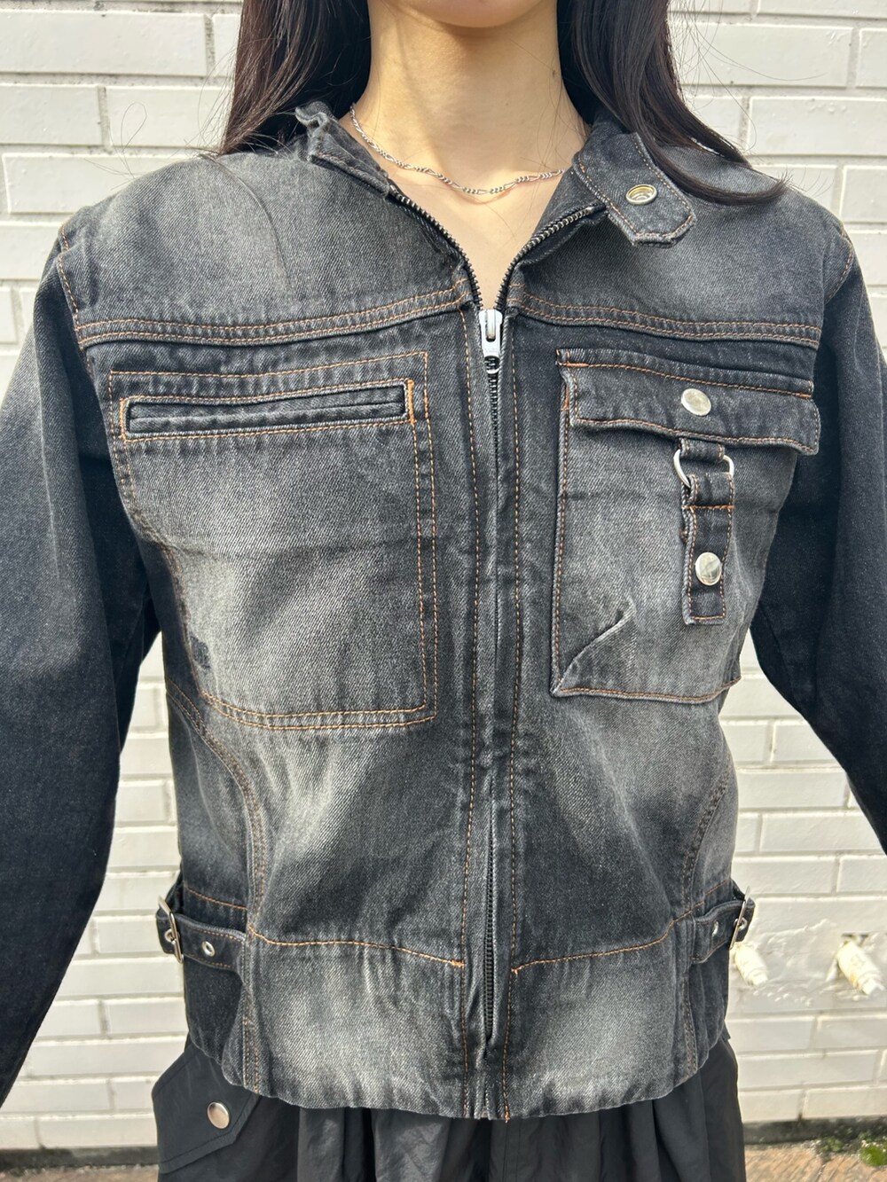 ブラック系のデニムジャケット、ブラック系のスカートを着用したレディースの冬コーディネートの3枚目の写真