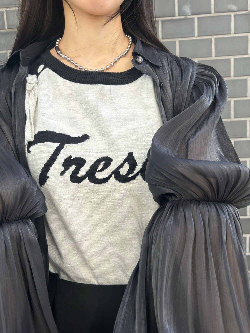 ブラック系のシャツ/ブラウス、ホワイト系のニット/セーター、ブラック系のスカートを着用したレディースの春コーディネートの5枚目の写真