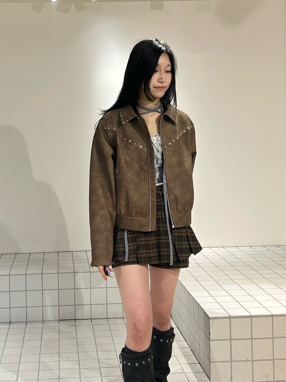 ブラック系のブーツ、ブラウン系のスカート、ブラウン系のブルゾンを着用したレディースの冬コーディネートの4枚目の写真