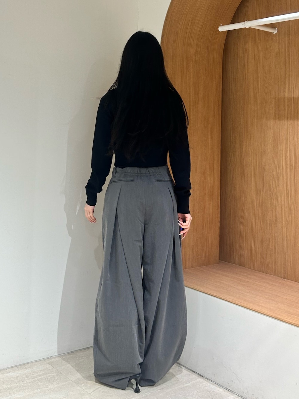 ブラック系のパンプス、グレー系のスラックス、ブラック系のカーディガン/ボレロを着用したレディースの春コーディネートの3枚目の写真