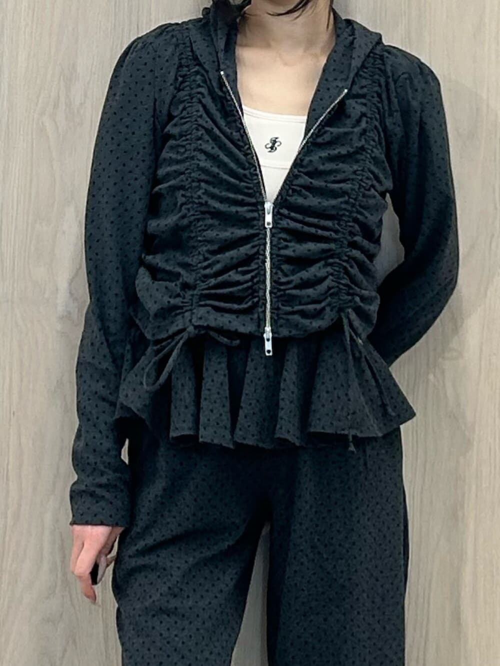 ブラック系のパンプス、ホワイト系のキャミソール、グレー系のスウェットパンツを着用したレディースの春コーディネートの6枚目の写真