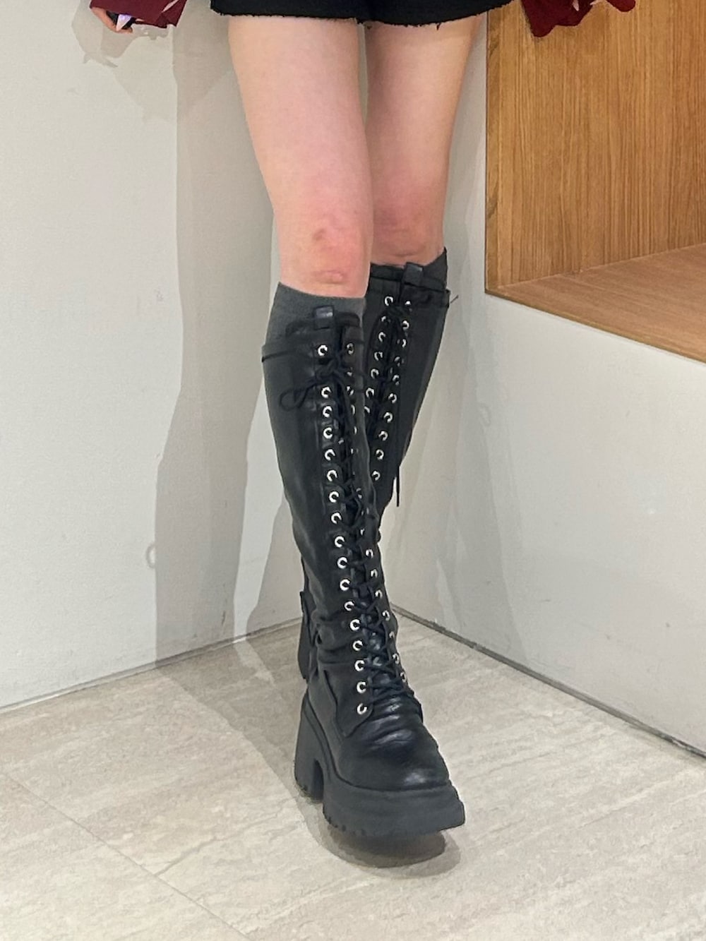 レッド系のニット/セーター、ブラック系のその他パンツ、ブラック系のブーツを着用したレディースの春コーディネートの7枚目の写真