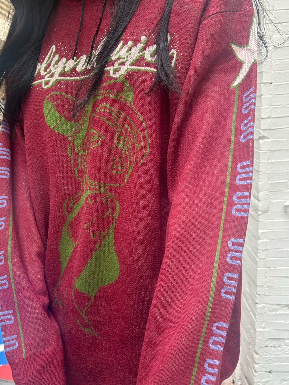 レッド系のニット/セーター、ブラック系のスカート、ブラック系のチョーカーを着用したレディースの秋コーディネートの7枚目の写真