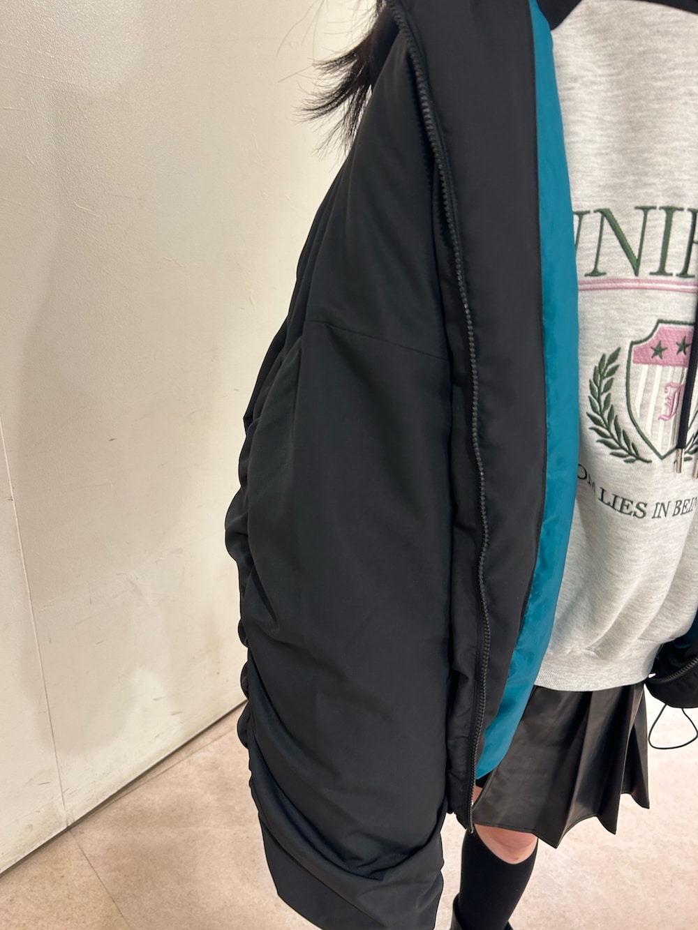 ブラック系のその他アウター、グレー系のパーカー、ブラック系のスカートを着用したレディースの冬コーディネートの5枚目の写真