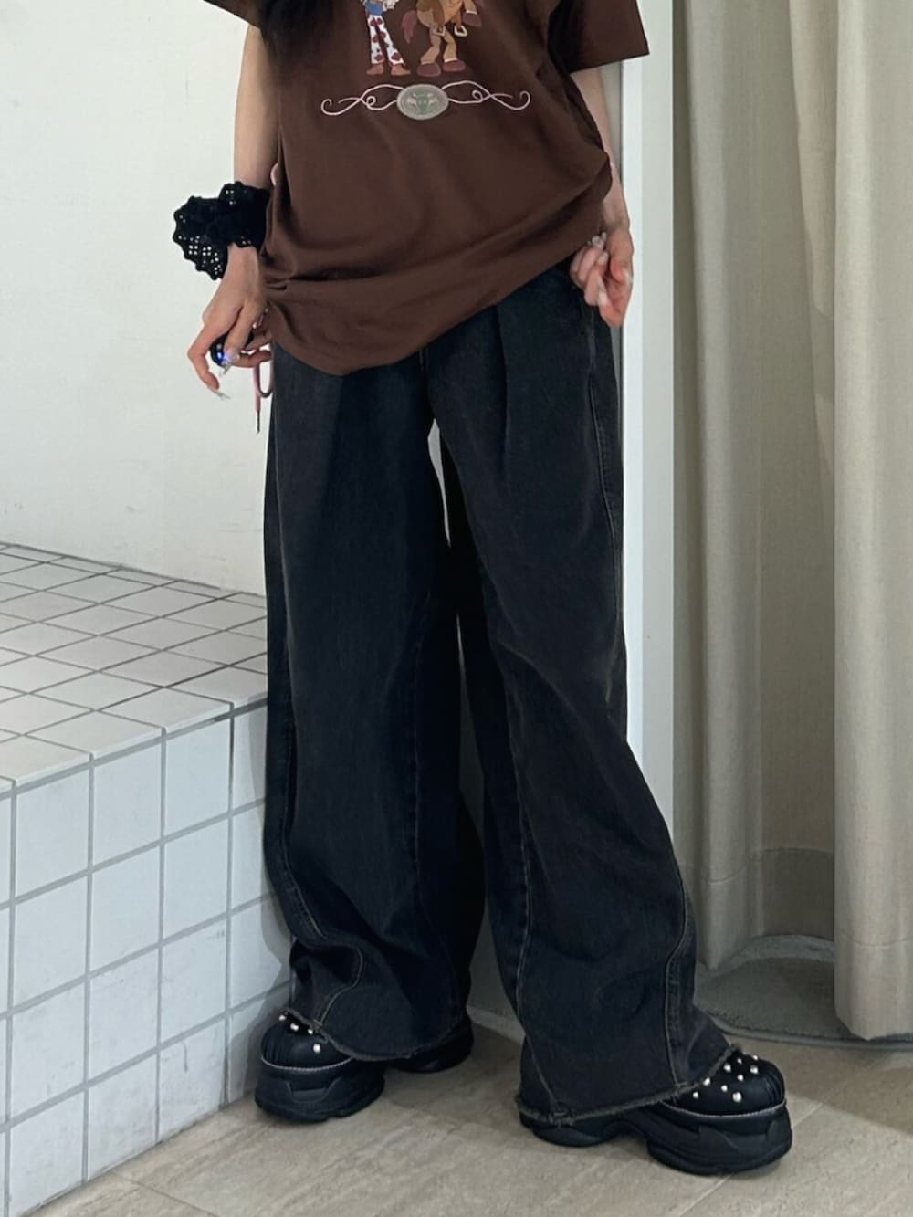 ブラック系のサンダル、ブラック系のデニムパンツ、ブラウン系のワンピースを着用したレディースの夏コーディネートの7枚目の写真