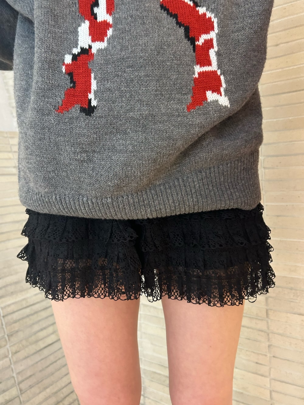 ゴールド系のパンプス、ブラック系のその他パンツ、レッド系のトートバッグを着用したレディースの冬コーディネートの7枚目の写真