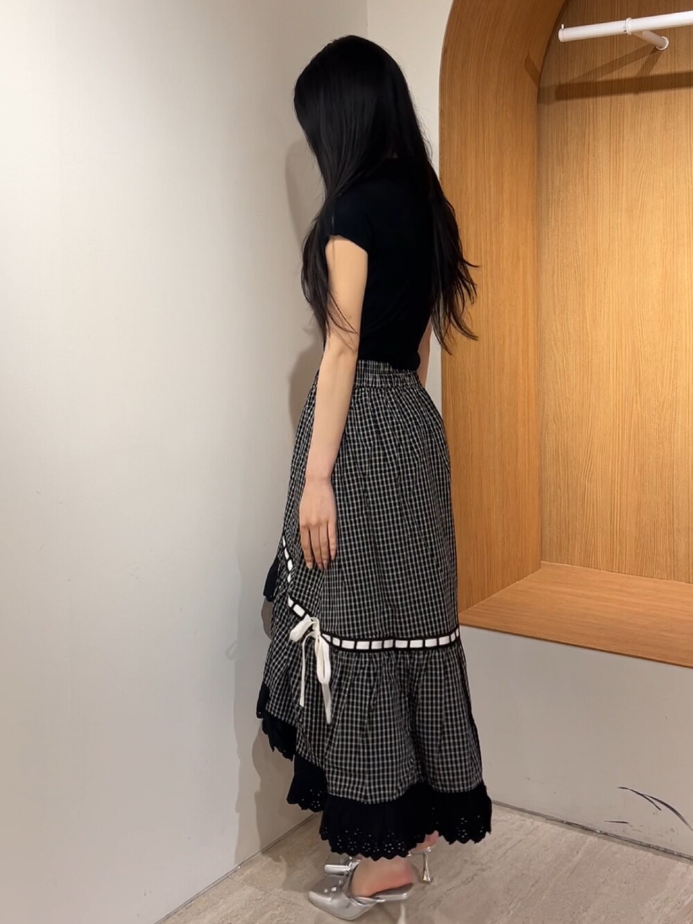 シルバー系のパンプス、ブラック系のスカート、ブラック系のニット/セーターを着用したレディースの夏コーディネートの2枚目の写真