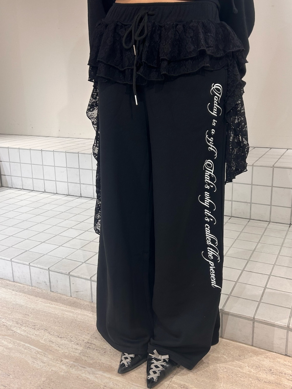 ブラック系のスウェット、ブラック系のスウェットパンツ、ブラック系のパンプスを着用したレディースの冬コーディネートの7枚目の写真