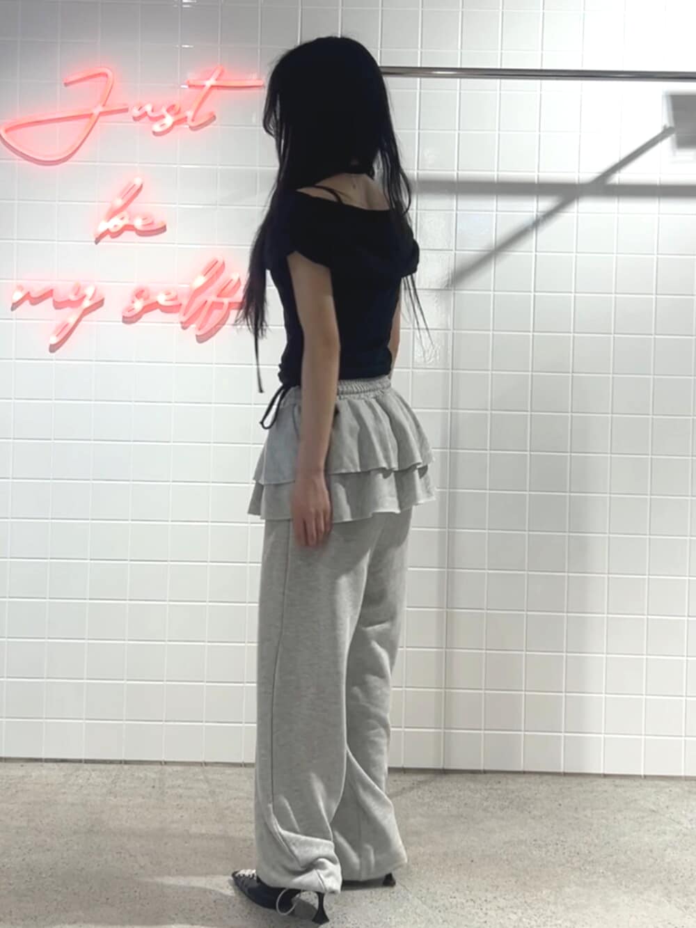 ブラック系のパンプス、グレー系のスウェットパンツ、ブラック系のTシャツ/カットソーを着用したレディースの秋コーディネートの2枚目の写真