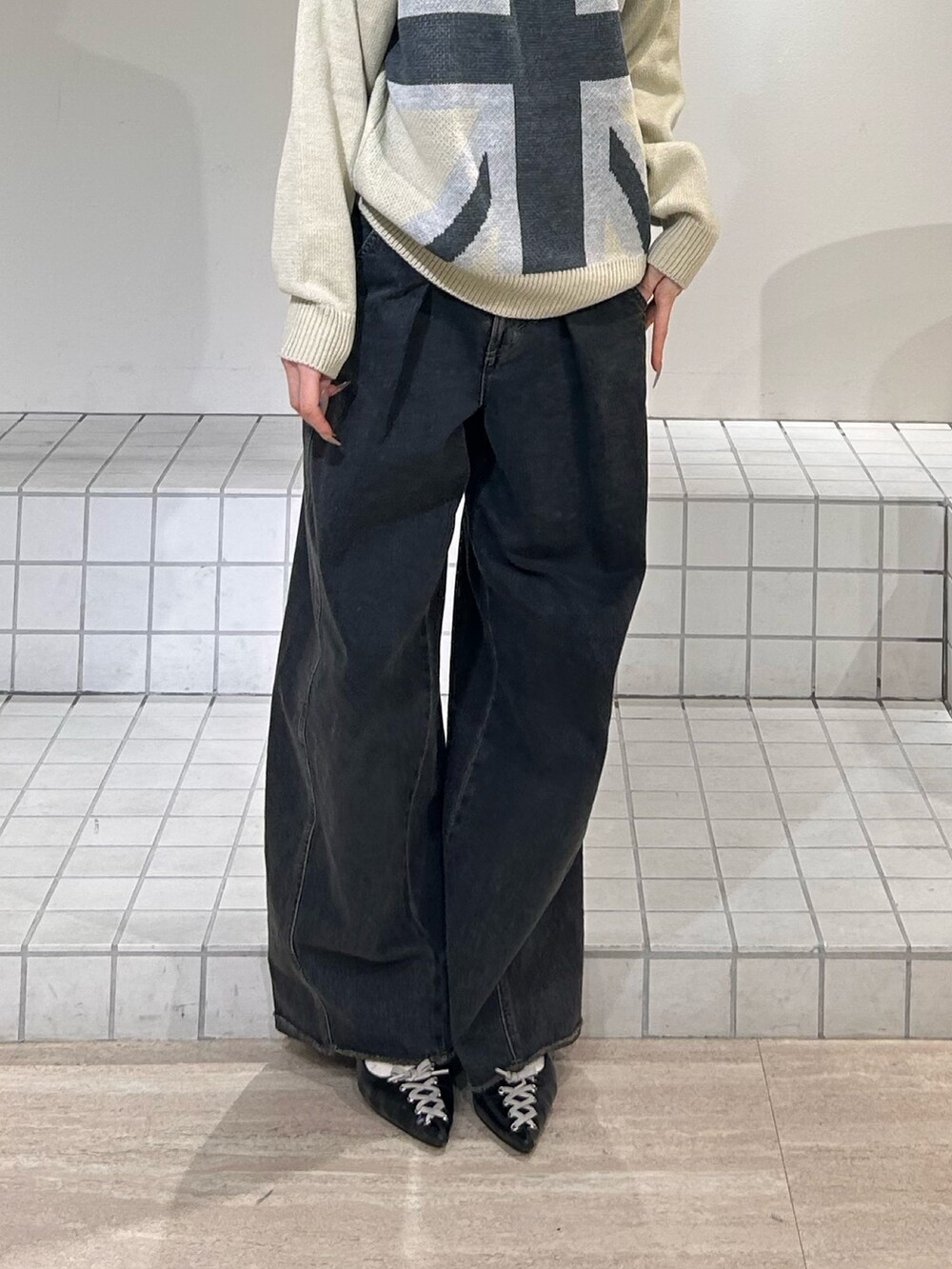 ホワイト系のニット/セーター、ブルー系のデニムパンツ、ブラック系のパンプスを着用したレディースの冬コーディネートの6枚目の写真