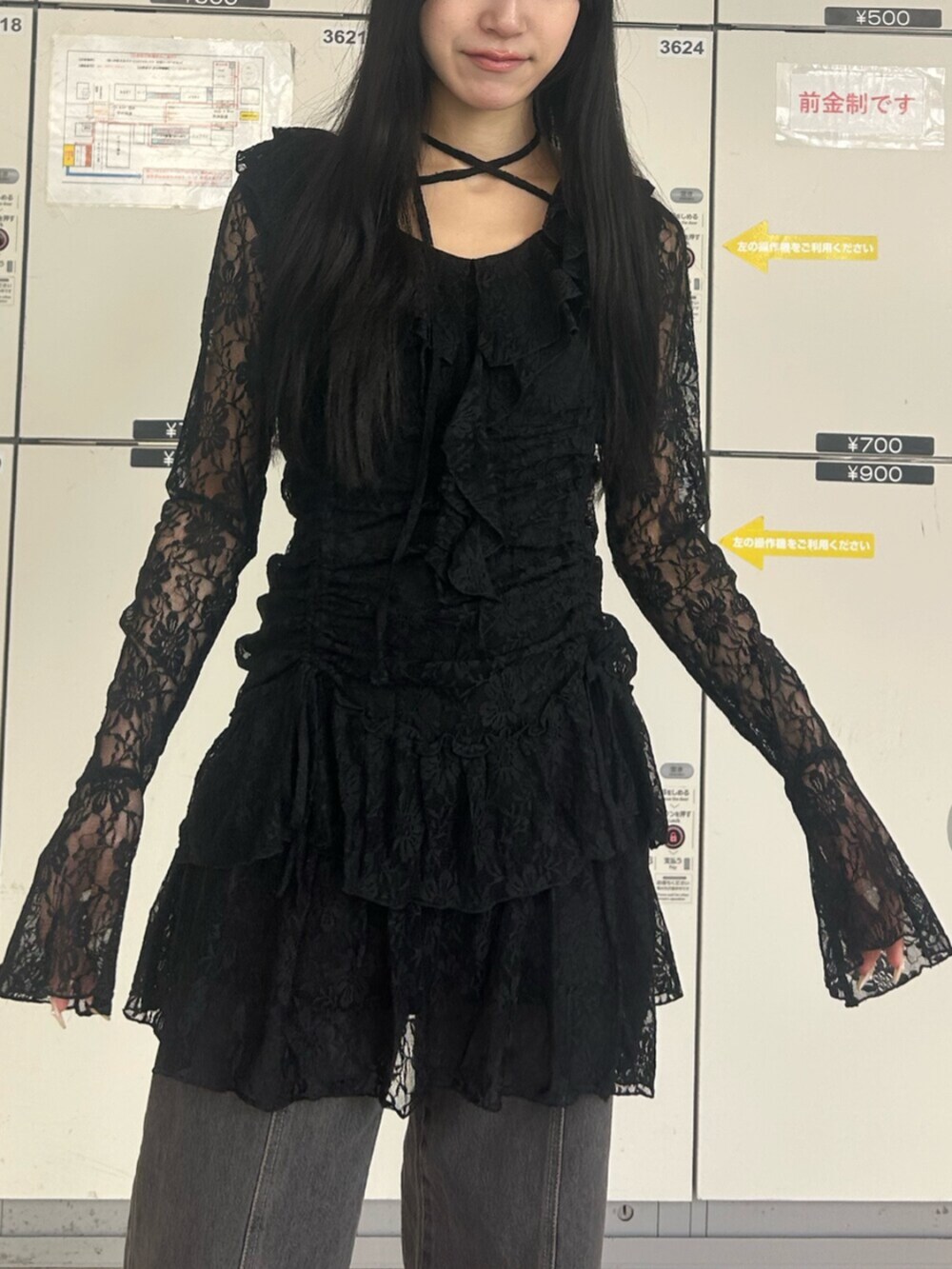 ゴールド系のパンプス、ブラック系のワンピース、ブラック系のデニムパンツを着用したレディースの冬コーディネートの4枚目の写真