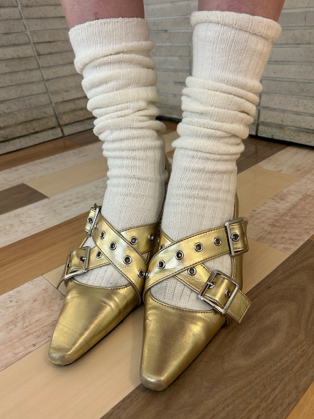 ゴールド系のパンプス、ブラック系のその他パンツ、レッド系のトートバッグを着用したレディースの冬コーディネートの9枚目の写真