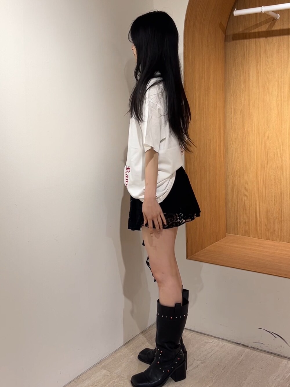 ホワイト系のTシャツ/カットソー、ブラック系のスカート、ブラック系のブーツを着用したレディースの夏コーディネートの2枚目の写真