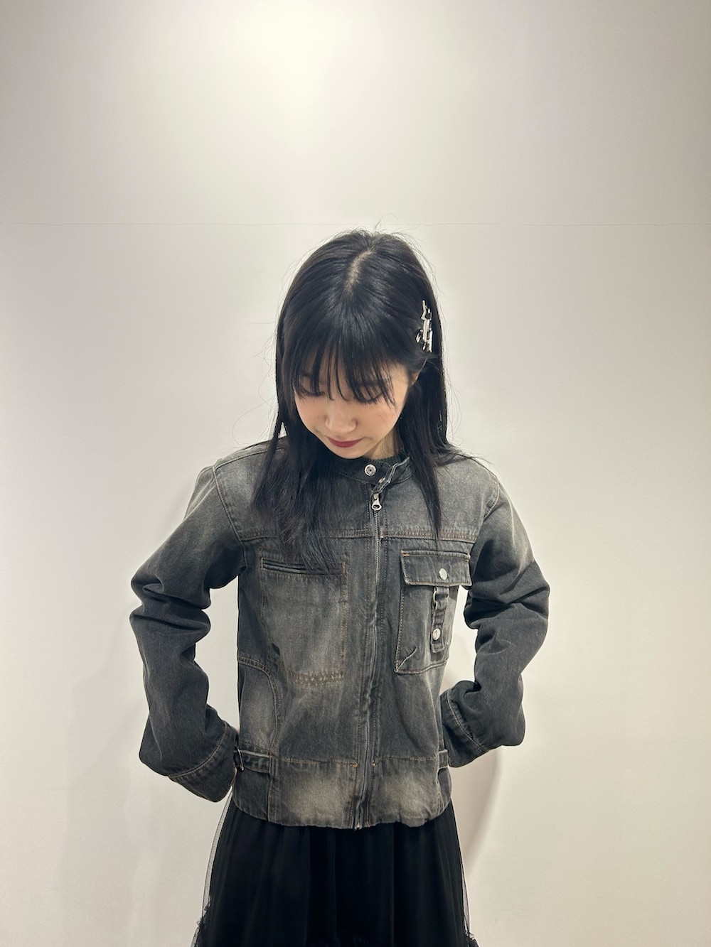 ブラック系のデニムジャケット、ブラック系のスカートを着用したレディースの冬コーディネートの3枚目の写真