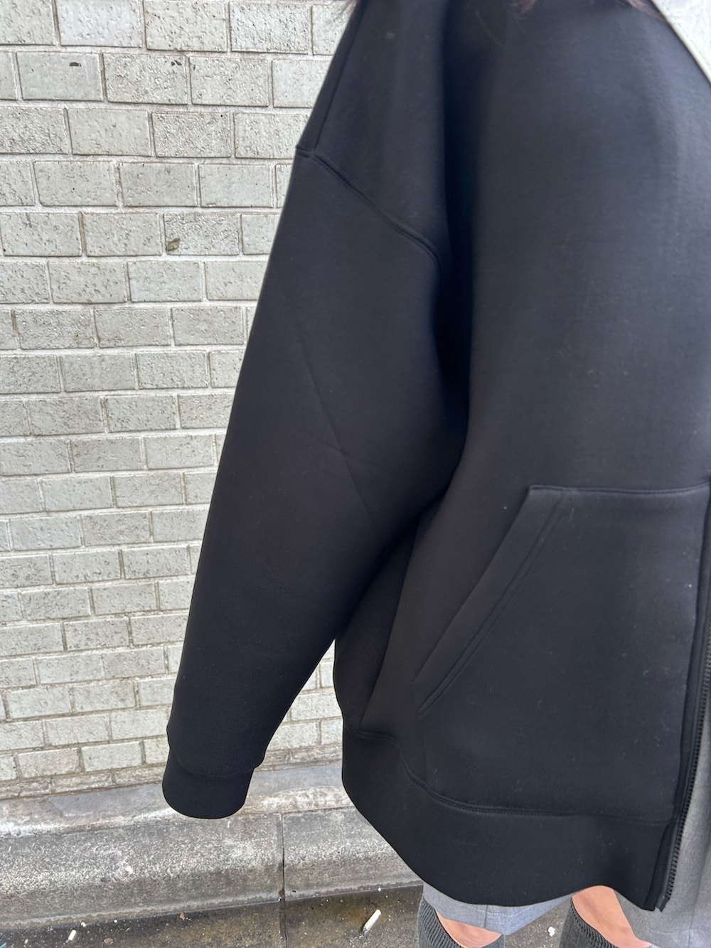 ブラック系のパーカー、グレー系のスカート、シルバー系のショルダーバッグを着用したレディースの冬コーディネートの4枚目の写真