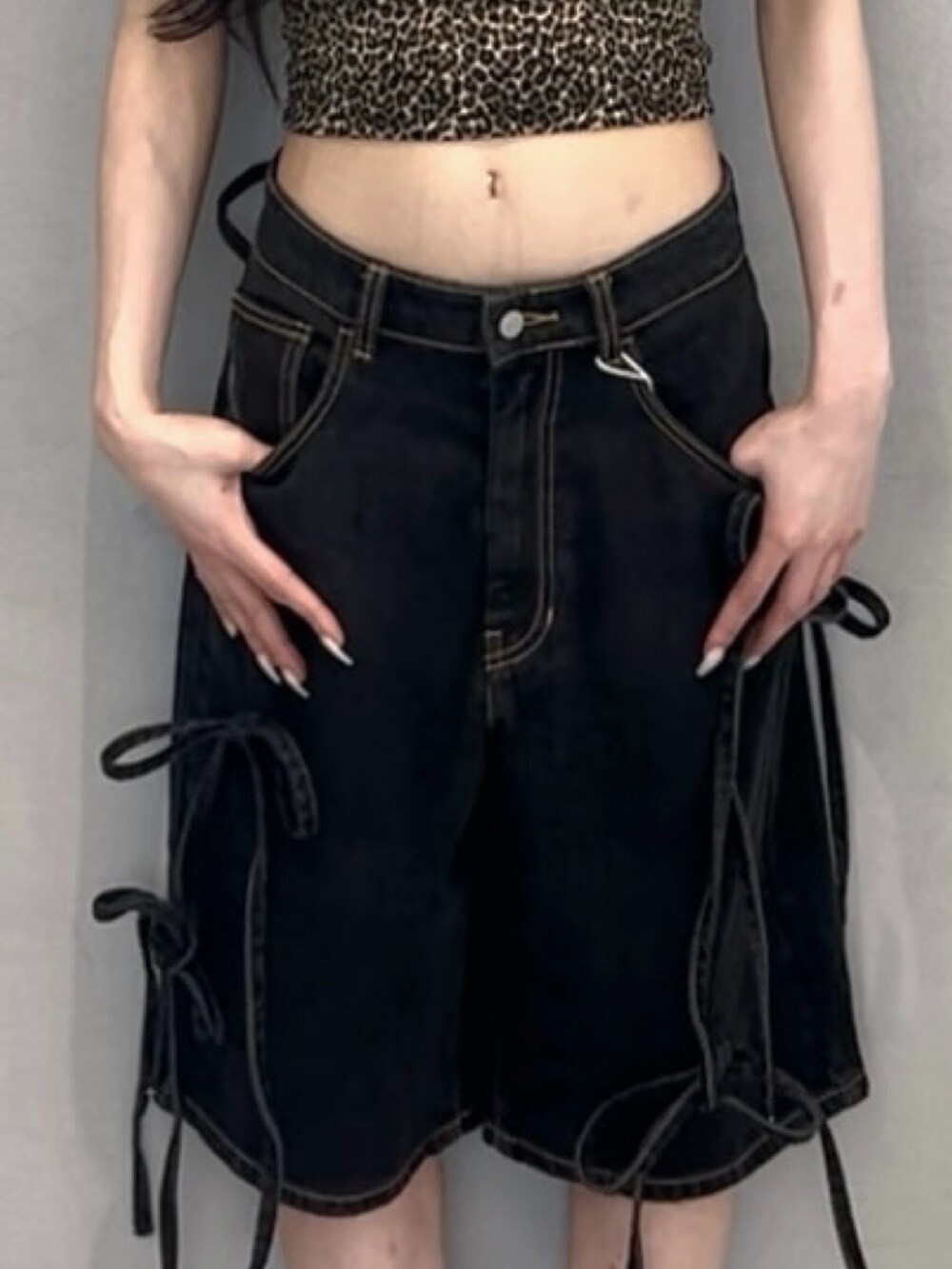 ブラウン系のキャミソール、ブラック系のデニムパンツ、ホワイト系のスニーカーを着用したレディースの春コーディネートの6枚目の写真