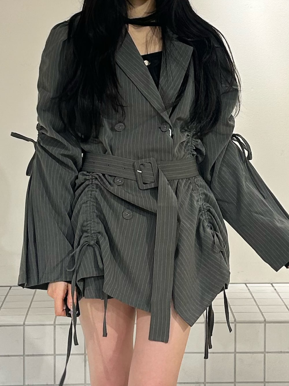 ブラック系のブーツ、グレー系のテーラードジャケット、ブラック系のニット/セーターを着用したレディースの冬コーディネートの5枚目の写真