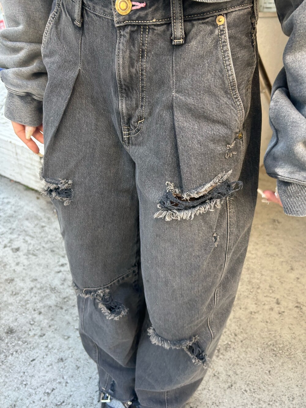 ブラック系のデニムパンツ、ブラック系のスウェット、ブラック系のパンプスを着用したレディースの冬コーディネートの6枚目の写真