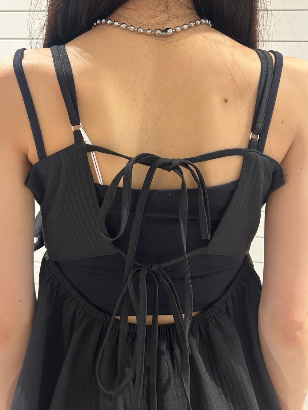 ブラック系のキャミソール、ブラック系のデニムパンツ、その他のショルダーバッグを着用したレディースの夏コーディネートの9枚目の写真