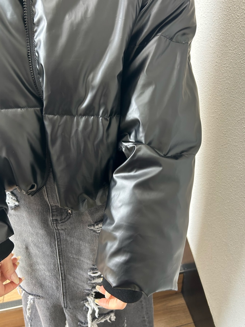 ブラック系のダウンジャケット/コート、ブラック系のニット/セーター、ブラック系のデニムスカートを着用したレディースの冬コーディネートの5枚目の写真