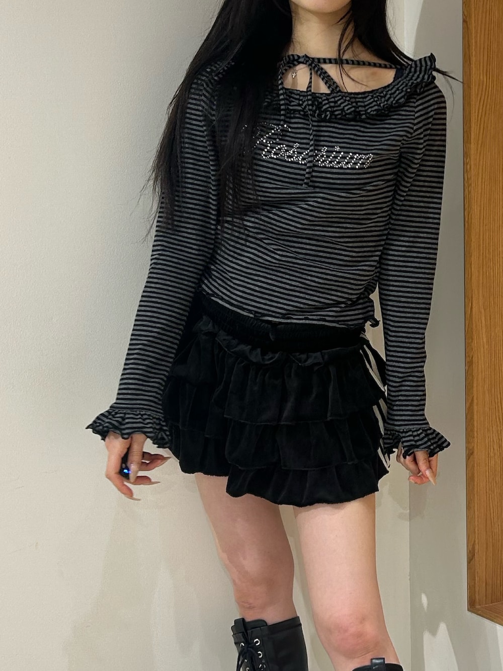 ブラック系のスカート、ブラック系のブーツ、ブラック系のTシャツ/カットソーを着用したレディースの秋コーディネートの5枚目の写真