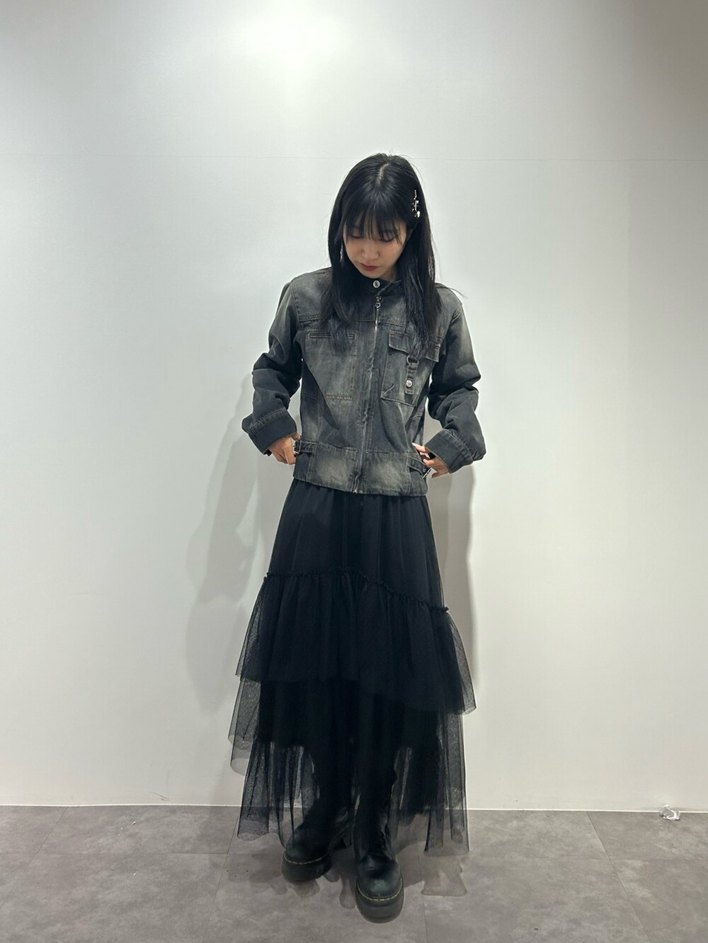 ブラック系のデニムジャケット、ブラック系のスカートを着用したレディースの冬コーディネートの2枚目の写真