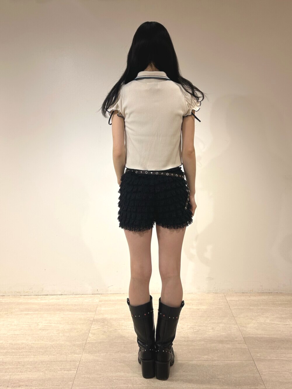 ブラック系のその他パンツ、ブラック系のブーツ、ホワイト系のポロシャツを着用したレディースの春コーディネートの3枚目の写真