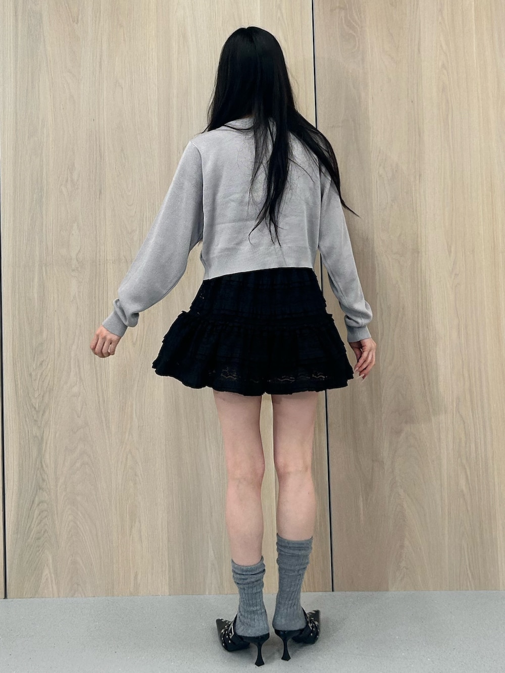 グレー系のニット/セーター、ブラック系のワンピース、ブラック系のパンプスを着用したレディースの春コーディネートの3枚目の写真