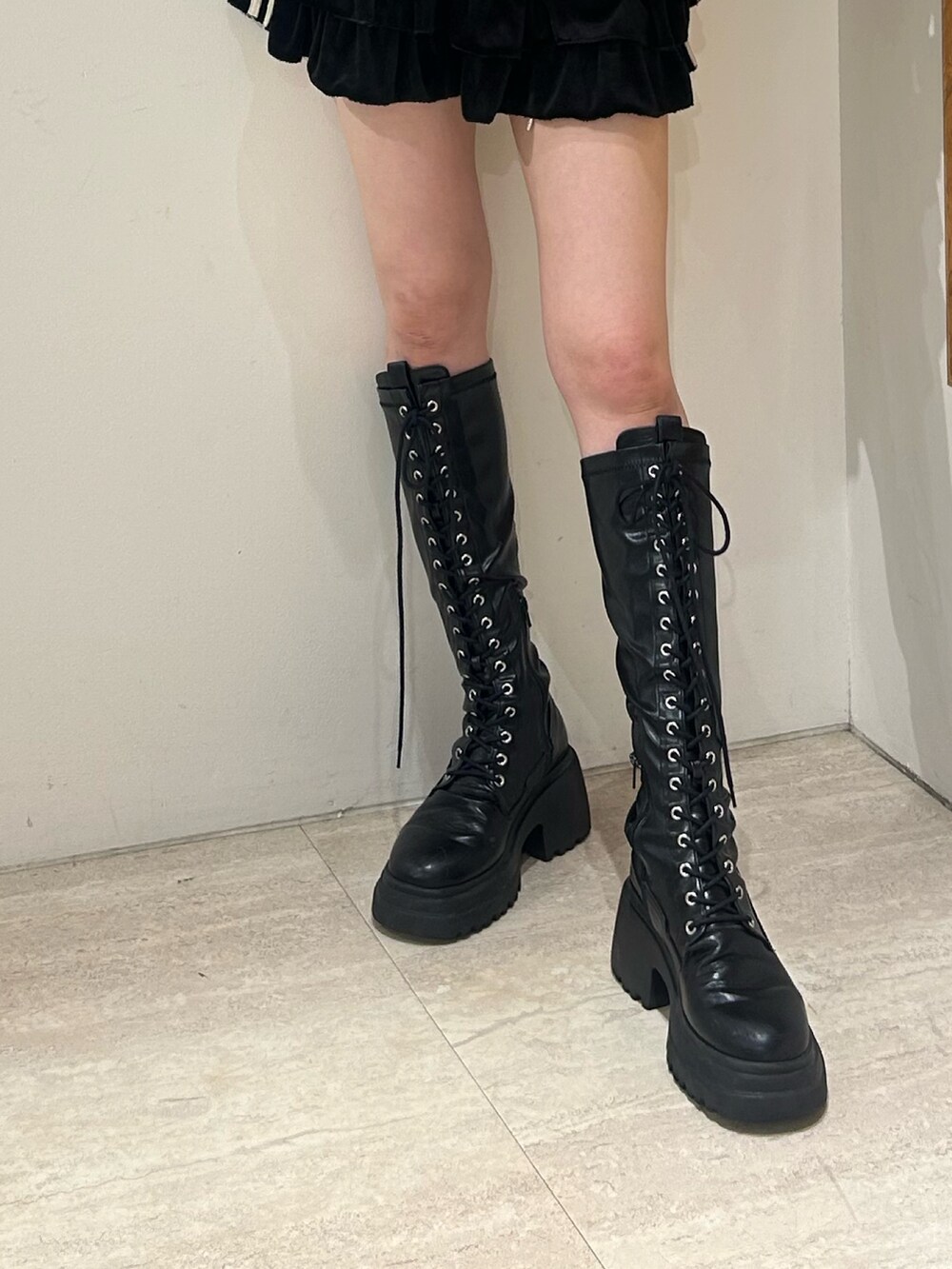 ブラック系のスカート、ブラック系のブーツ、ブラック系のTシャツ/カットソーを着用したレディースの秋コーディネートの6枚目の写真