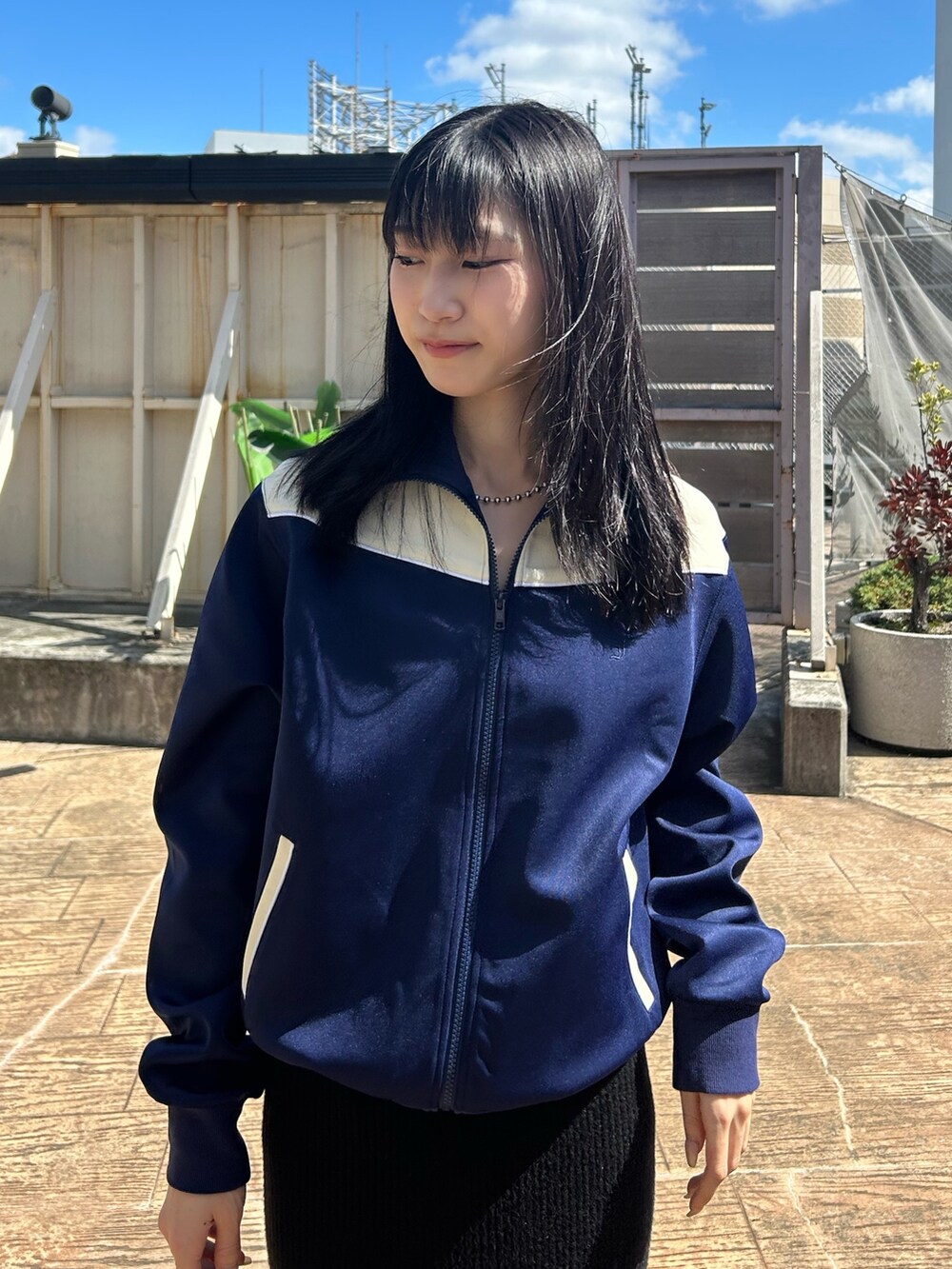 ブルー系のジャージ、ブラック系のスカートを着用したレディースの秋コーディネートの3枚目の写真