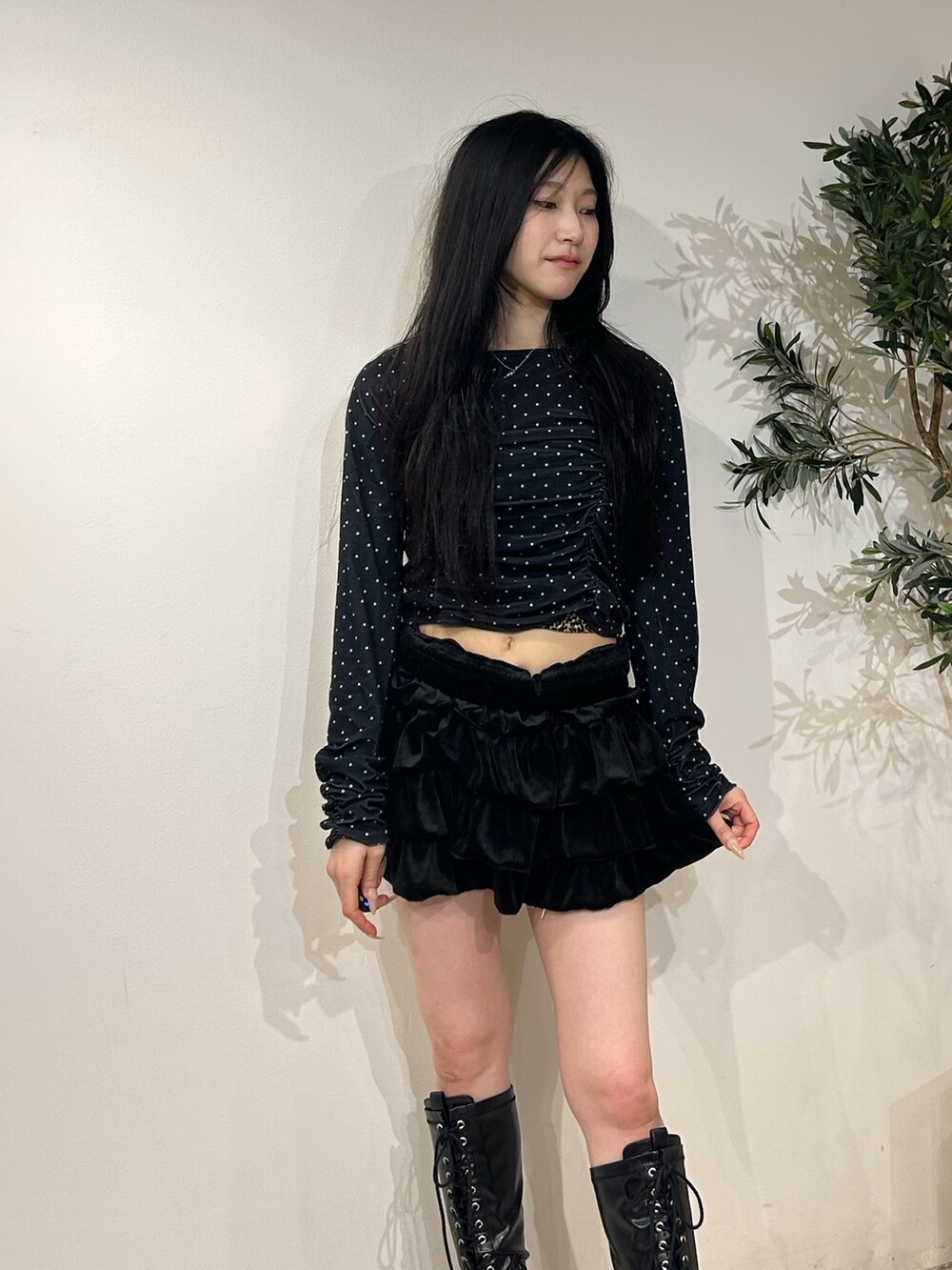 ブラック系のスカート、ブラック系のTシャツ/カットソー、ブラック系のブーツを着用したレディースの秋コーディネートの4枚目の写真