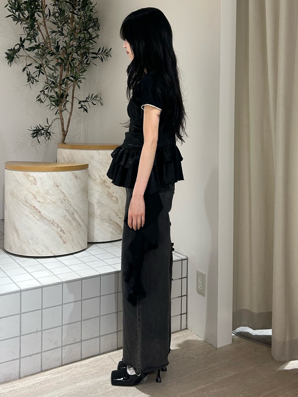 ブラック系のキャミソール、ブラック系のTシャツ/カットソー、ブラック系のデニムパンツを着用したレディースの春コーディネートの2枚目の写真