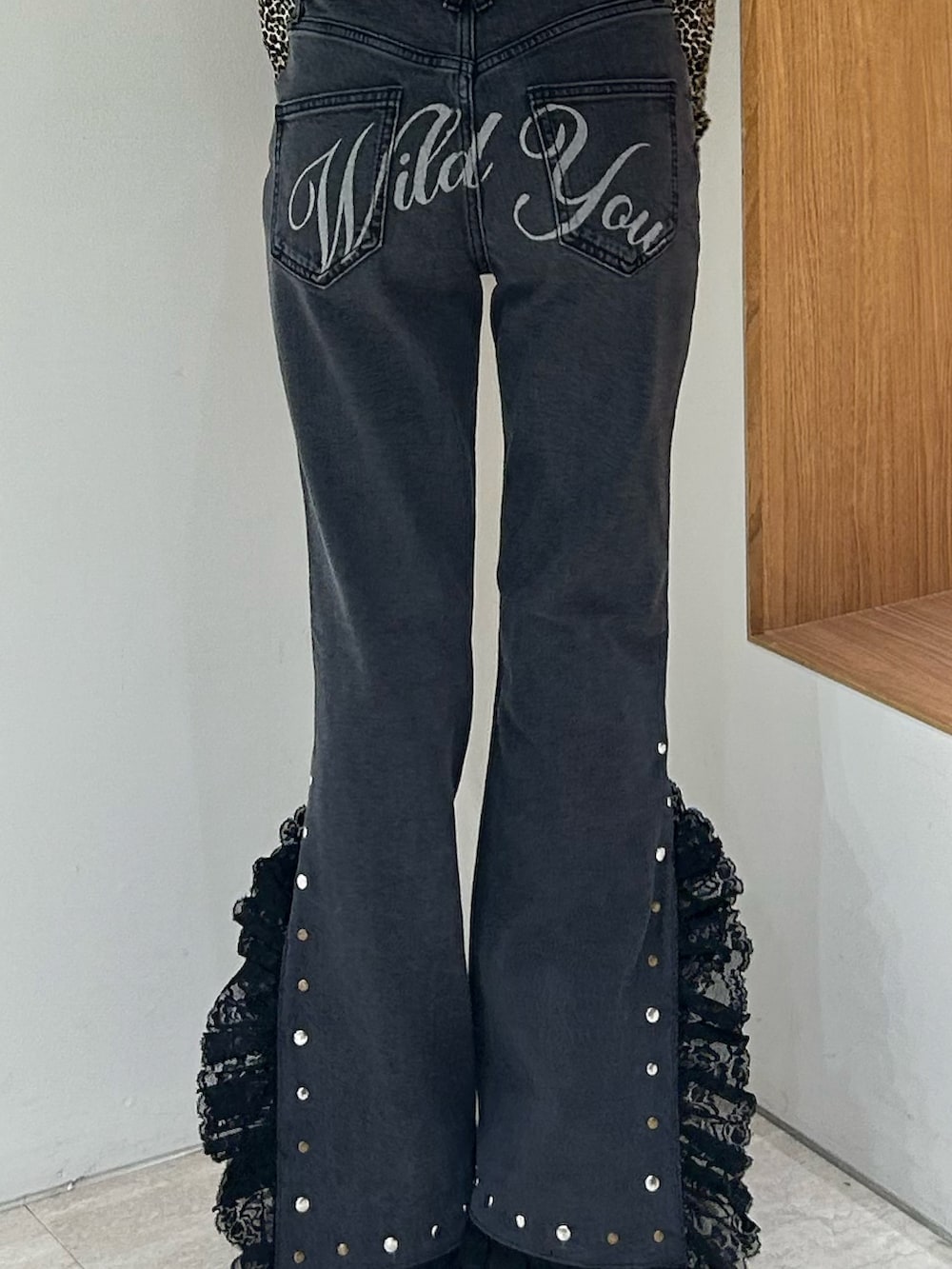 ブラック系のスウェット、ブラック系のデニムパンツ、ブラック系のパンプスを着用したレディースの冬コーディネートの7枚目の写真