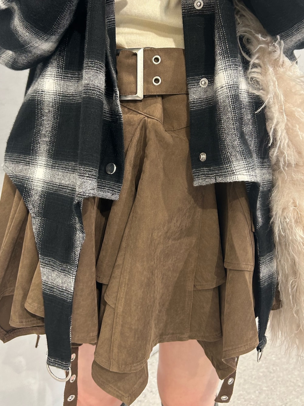 ホワイト系のショルダーバッグ、ベージュ系のブーツ、ブラウン系のスカートを着用したレディースの秋コーディネートの7枚目の写真