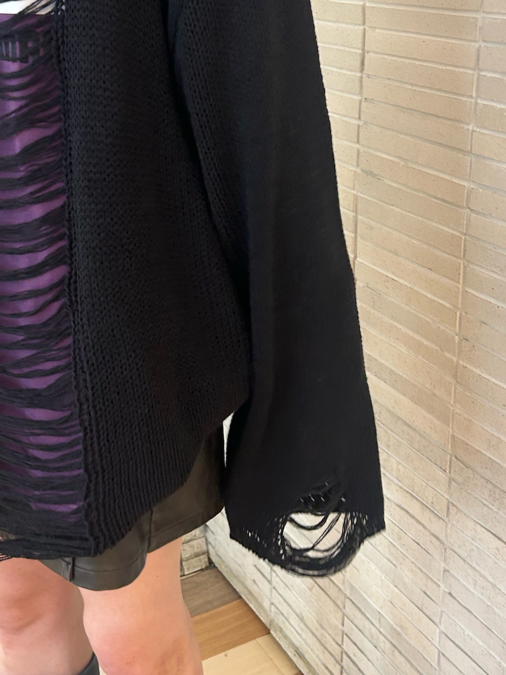 ブラック系のニット/セーター、パープル系のTシャツ/カットソー、ブラック系のスカートを着用したレディースの秋コーディネートの7枚目の写真