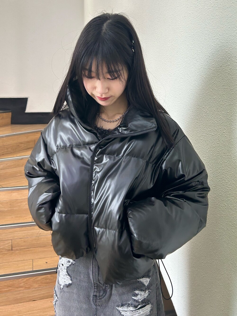 ブラック系のダウンジャケット/コート、ブラック系のニット/セーター、ブラック系のデニムスカートを着用したレディースの冬コーディネートの3枚目の写真