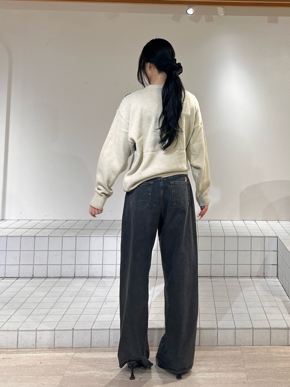 ホワイト系のニット/セーター、ブルー系のデニムパンツ、ブラック系のパンプスを着用したレディースの冬コーディネートの3枚目の写真