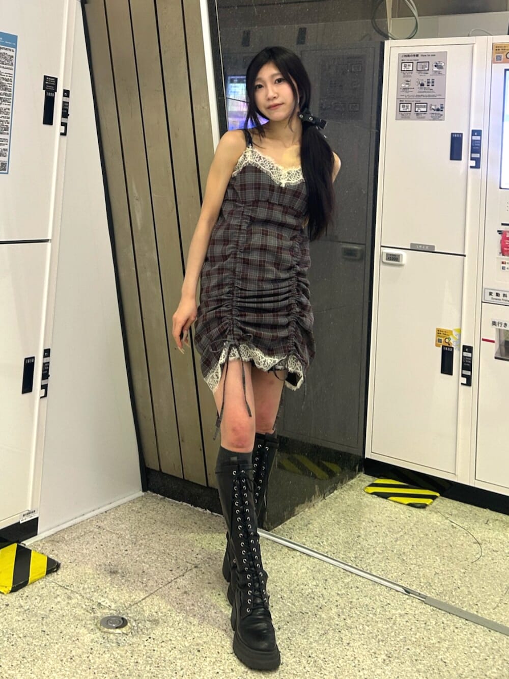 ブラック系のブーツ、ホワイト系のカーディガン/ボレロ、ブラック系のワンピースを着用したレディースの春コーディネートの2枚目の写真