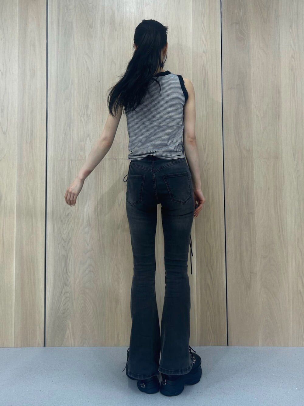ブラック系のデニムパンツ、ブラック系のパンプス、その他のタンクトップを着用したレディースの春コーディネートの3枚目の写真