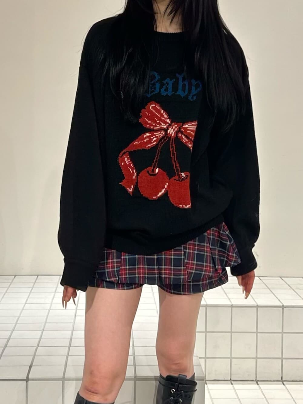 ブラック系のブーツ、ブラック系のニット/セーター、ブルー系のスカートを着用したレディースの秋コーディネートの5枚目の写真