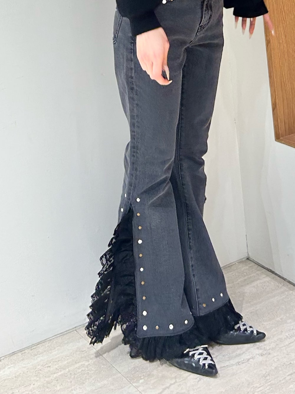 ブラック系のスウェット、ブラック系のデニムパンツ、ブラック系のパンプスを着用したレディースの冬コーディネートの8枚目の写真