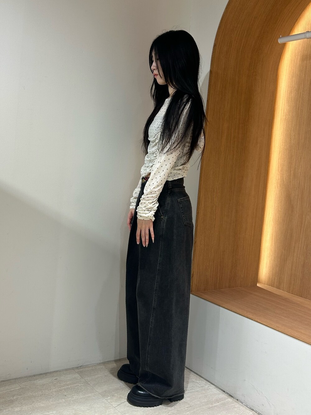ブラック系のデニムパンツ、ホワイト系のTシャツ/カットソーを着用したレディースの秋コーディネートの2枚目の写真