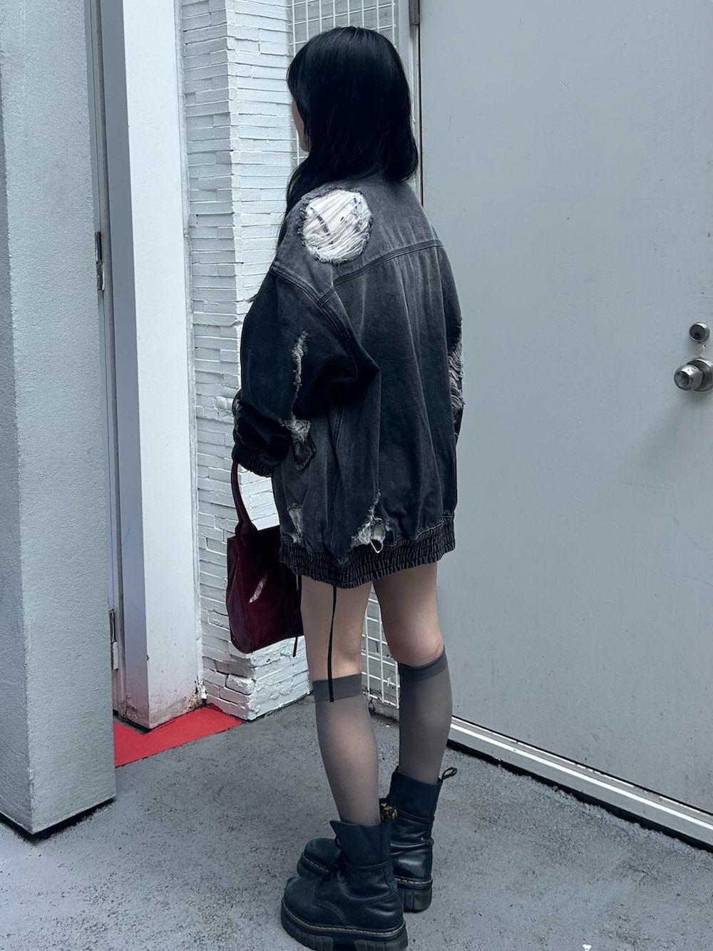 ホワイト系のTシャツ/カットソー、ブラック系のブルゾン、レッド系のハンドバッグを着用したレディースの秋コーディネートの2枚目の写真