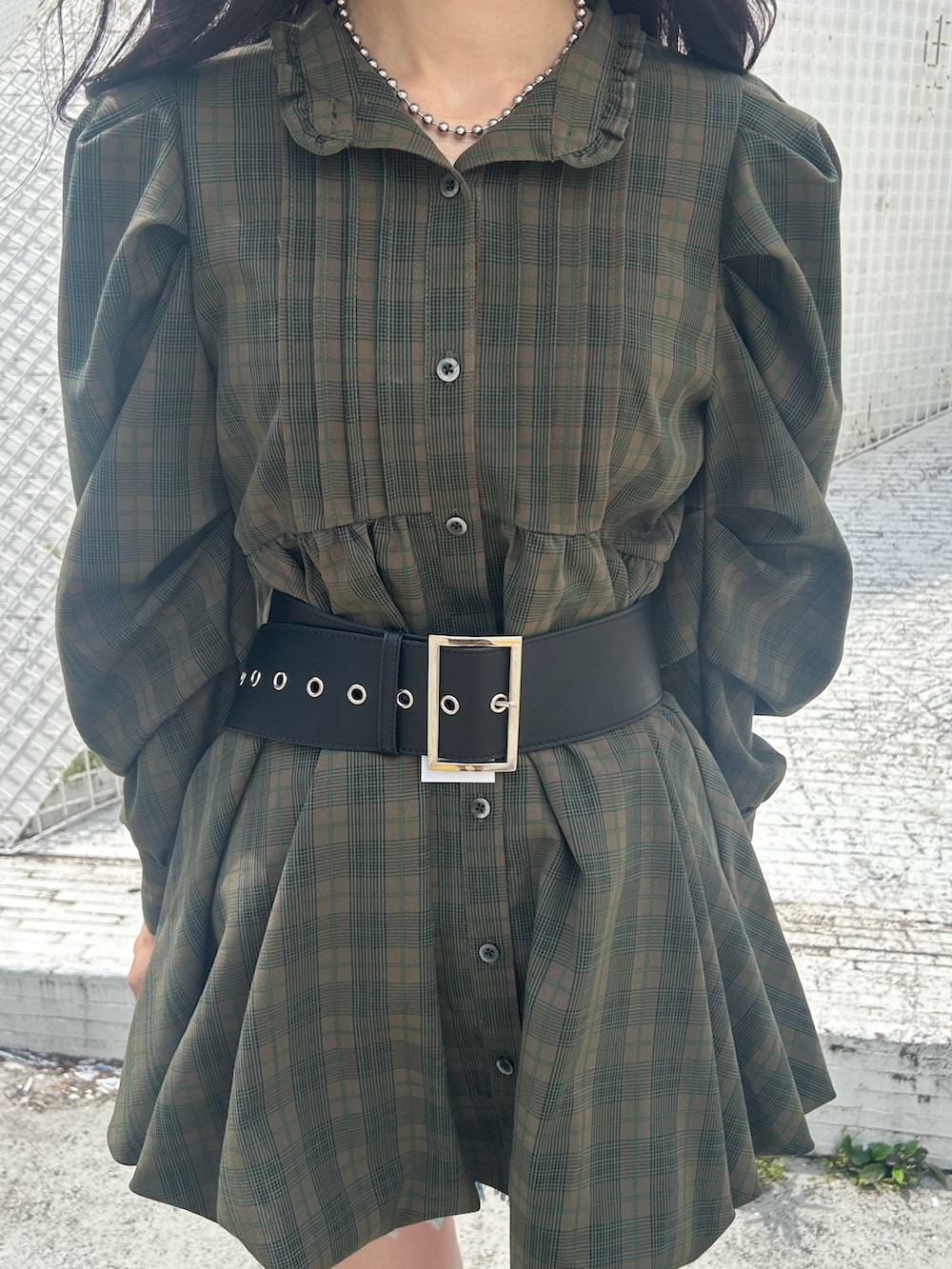 グリーン系のワンピース、ブルー系のデニムパンツ、ブラック系のベルトを着用したレディースの夏コーディネートの5枚目の写真