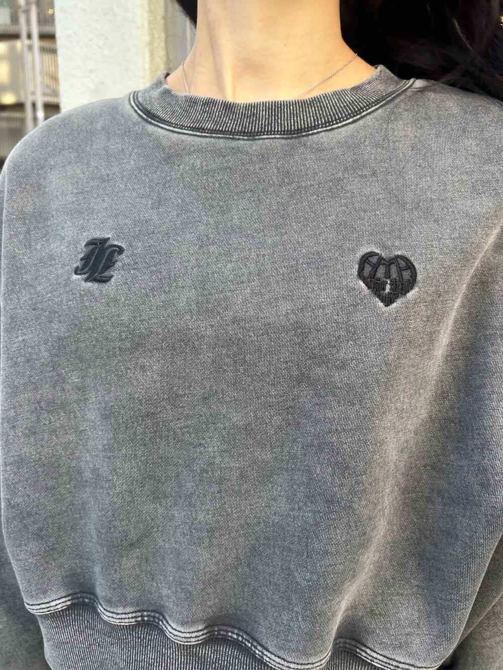 ブラック系のデニムパンツ、ブラック系のスウェット、ブラック系のパンプスを着用したレディースの冬コーディネートの5枚目の写真