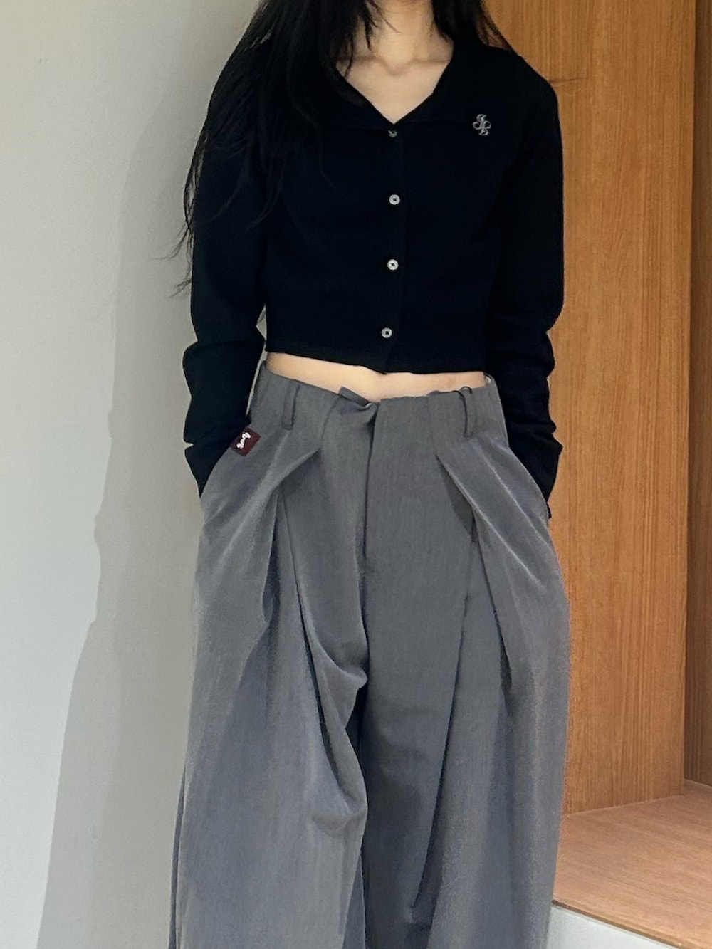 ブラック系のパンプス、グレー系のスラックス、ブラック系のカーディガン/ボレロを着用したレディースの春コーディネートの5枚目の写真