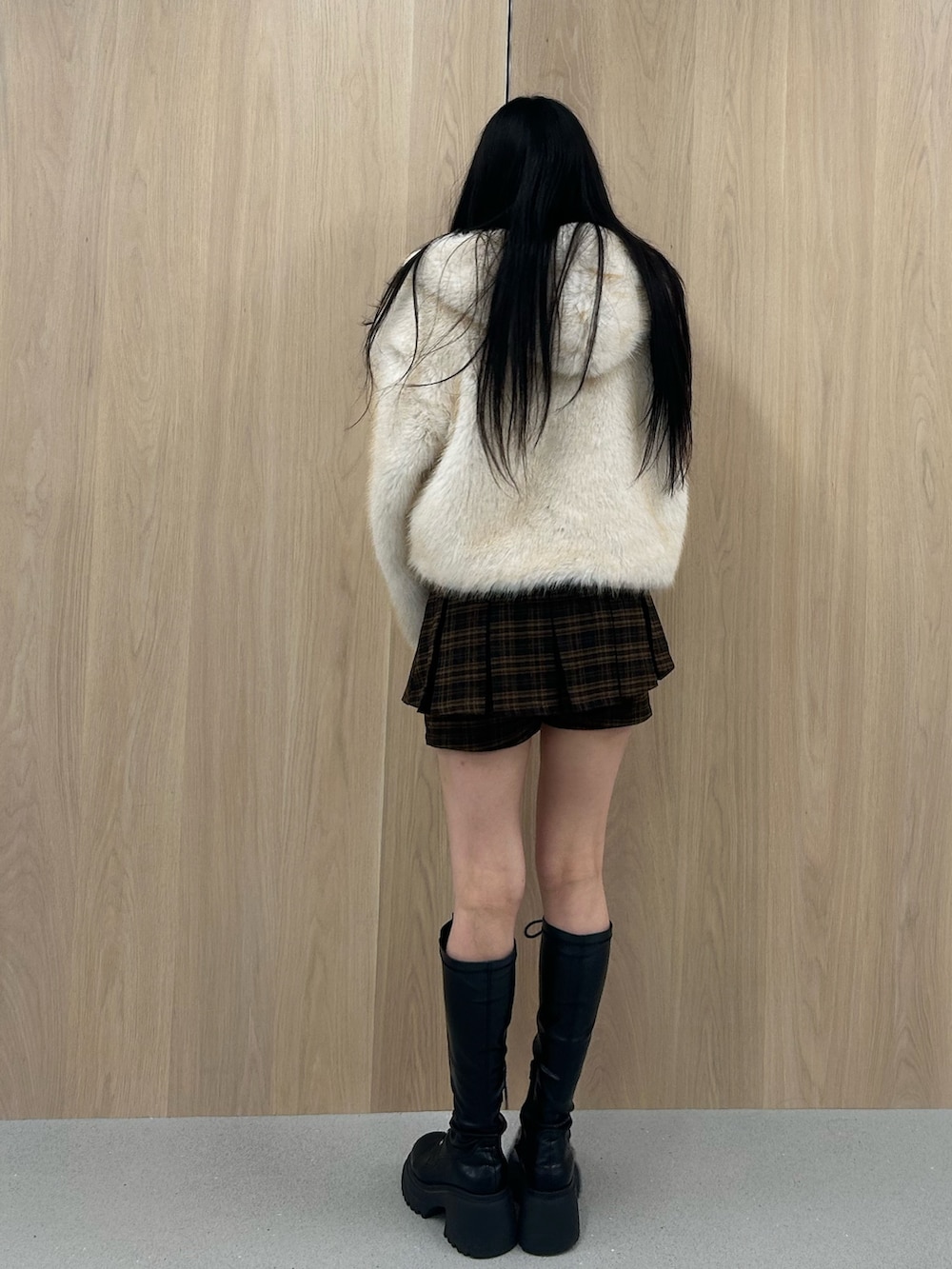 ホワイト系のブルゾン、ブラウン系のスカート、ブラック系のブーツを着用したレディースの秋コーディネートの3枚目の写真