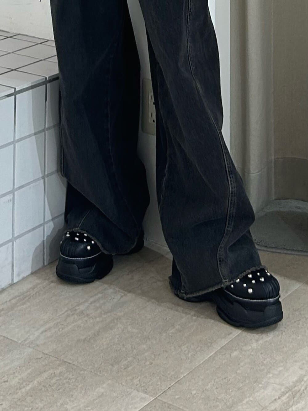 ブラック系のサンダル、ブラック系のデニムパンツ、ブラウン系のワンピースを着用したレディースの夏コーディネートの8枚目の写真