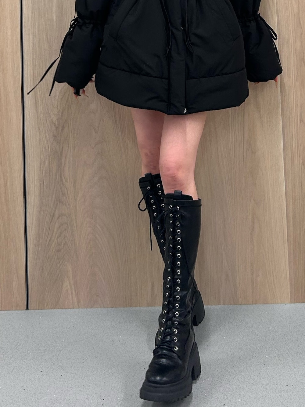 ブラック系のダウンジャケット/コート、ブラック系のブーツを着用したレディースの冬コーディネートの6枚目の写真